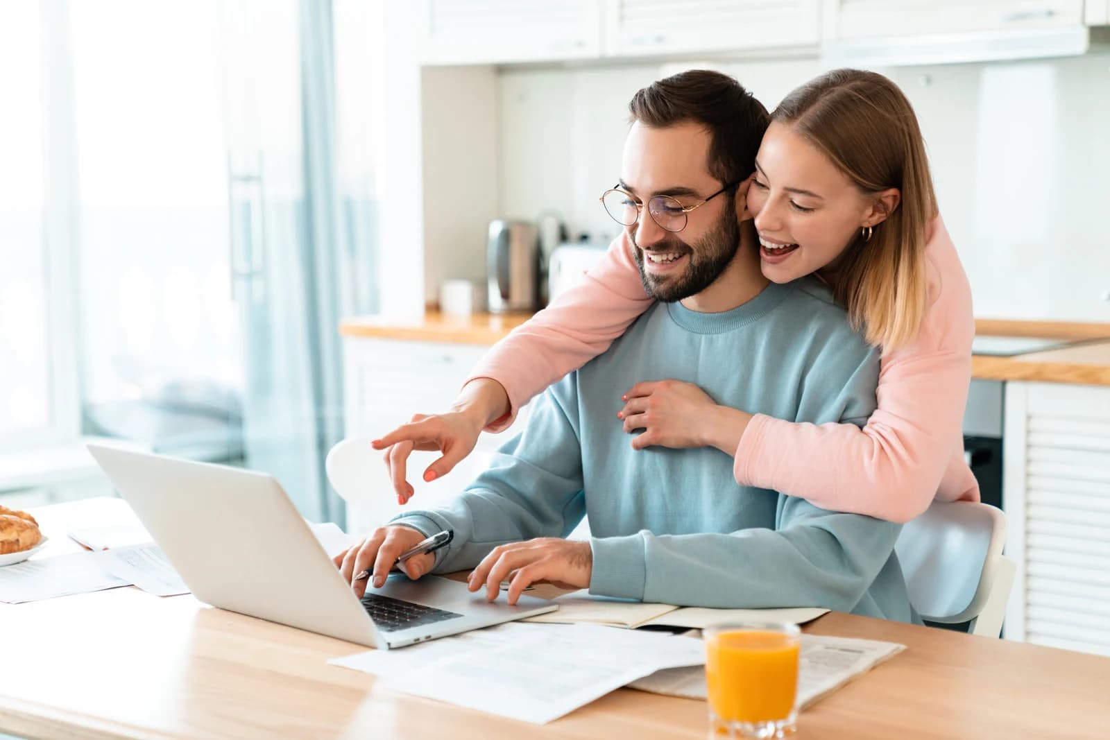 Professional couple reviewing financial documents on laptop